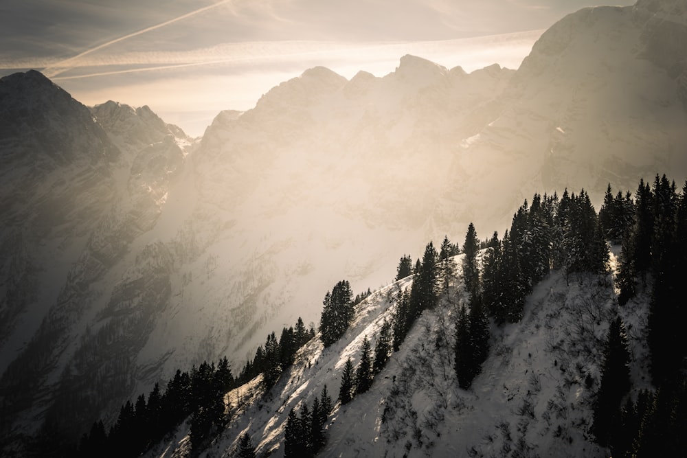 Il sole splende tra le nuvole sopra le montagne