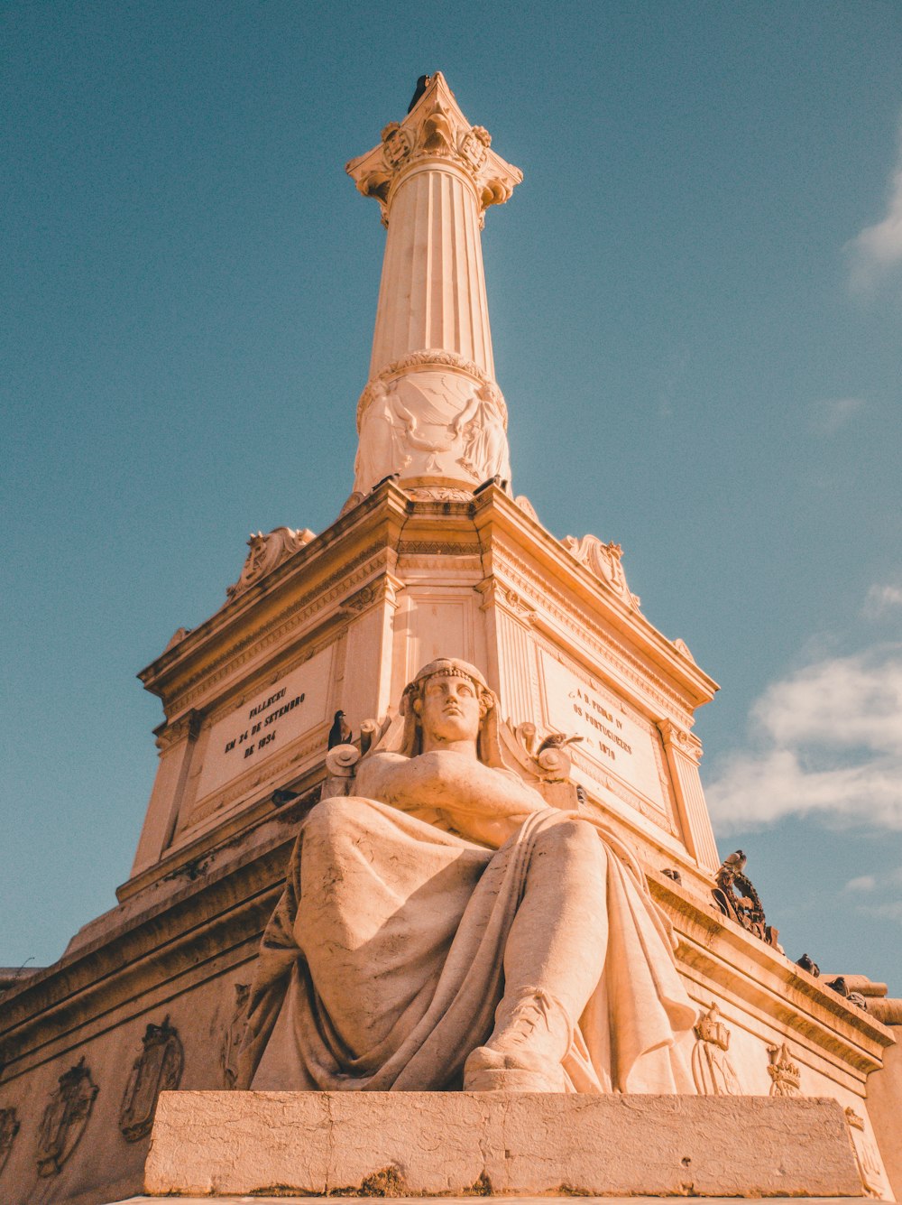 a statue of a woman sitting on top of a building