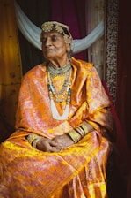 A caring financial planner discussing retirement plans with an elderly couple in traditional attire.