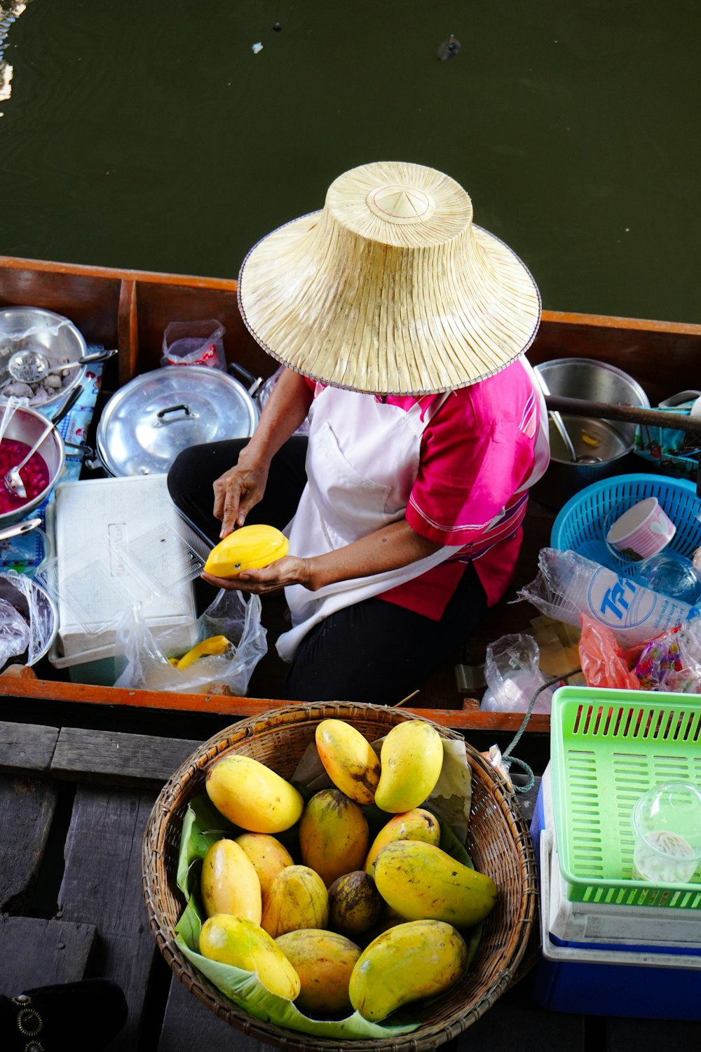 a woman in a straw hat sitting in a boat