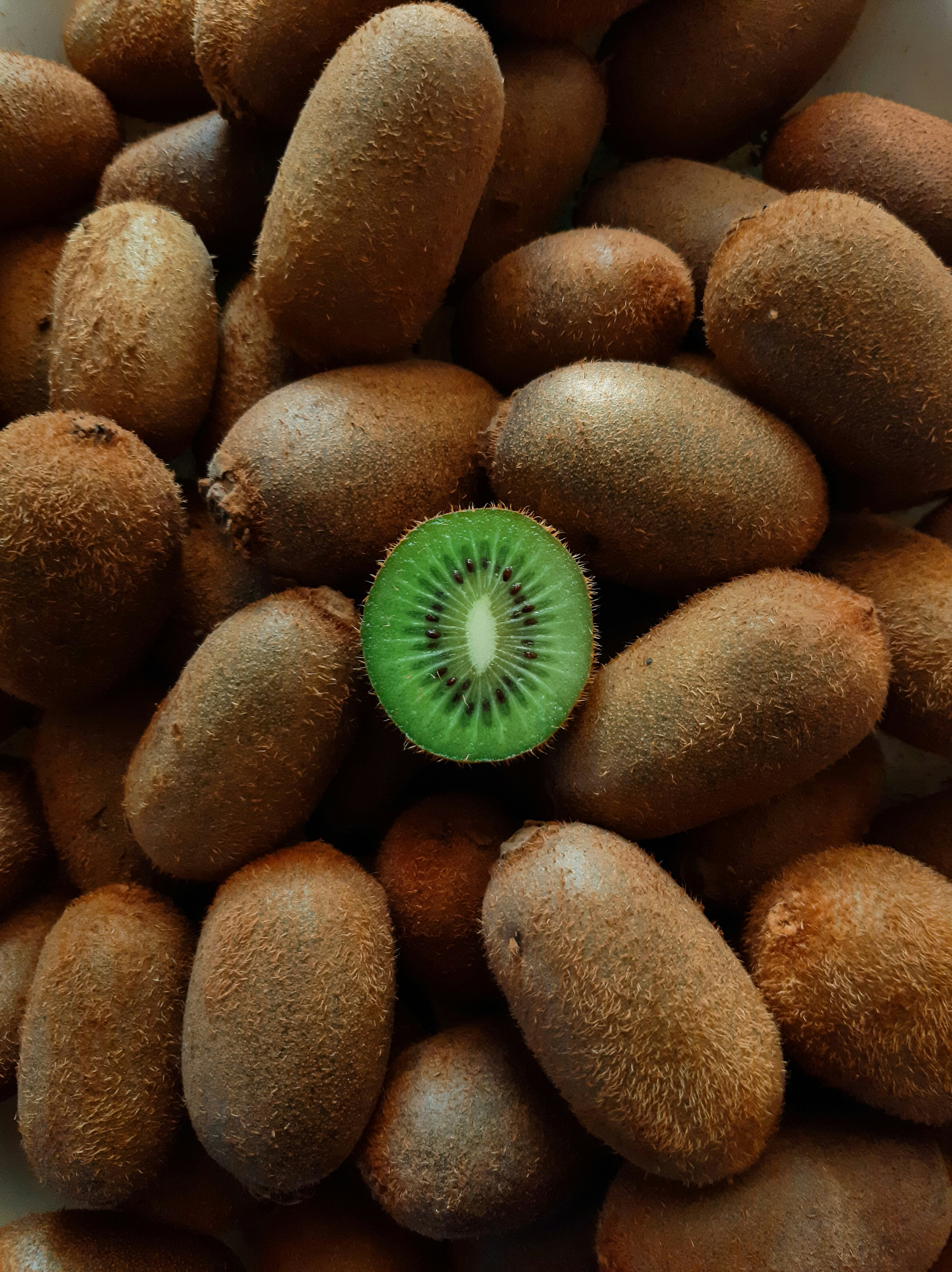 Fresh green kiwi fruits cut in half showing vibrant green flesh with white center