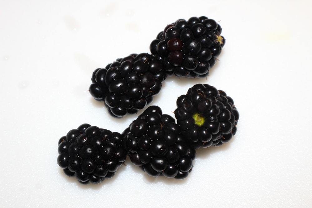 a group of blackberries sitting on top of a white table