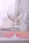 Close-up of a crystal-clear wine glass catching soft natural light on a marble countertop.