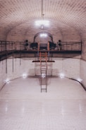 a ladder is in the middle of a white tiled room