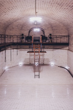 a ladder is in the middle of a white tiled room