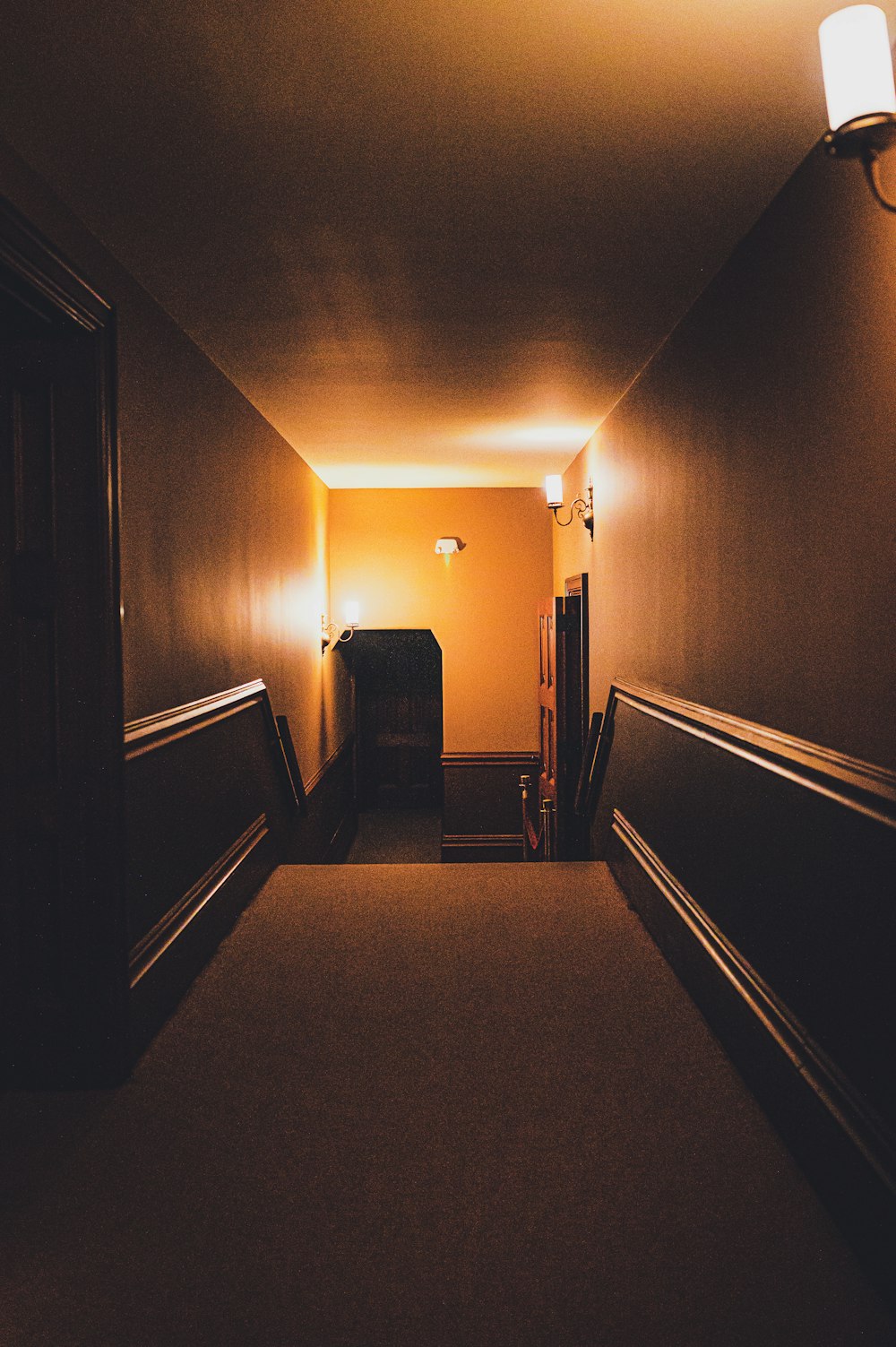 a dimly lit hallway leading to another room