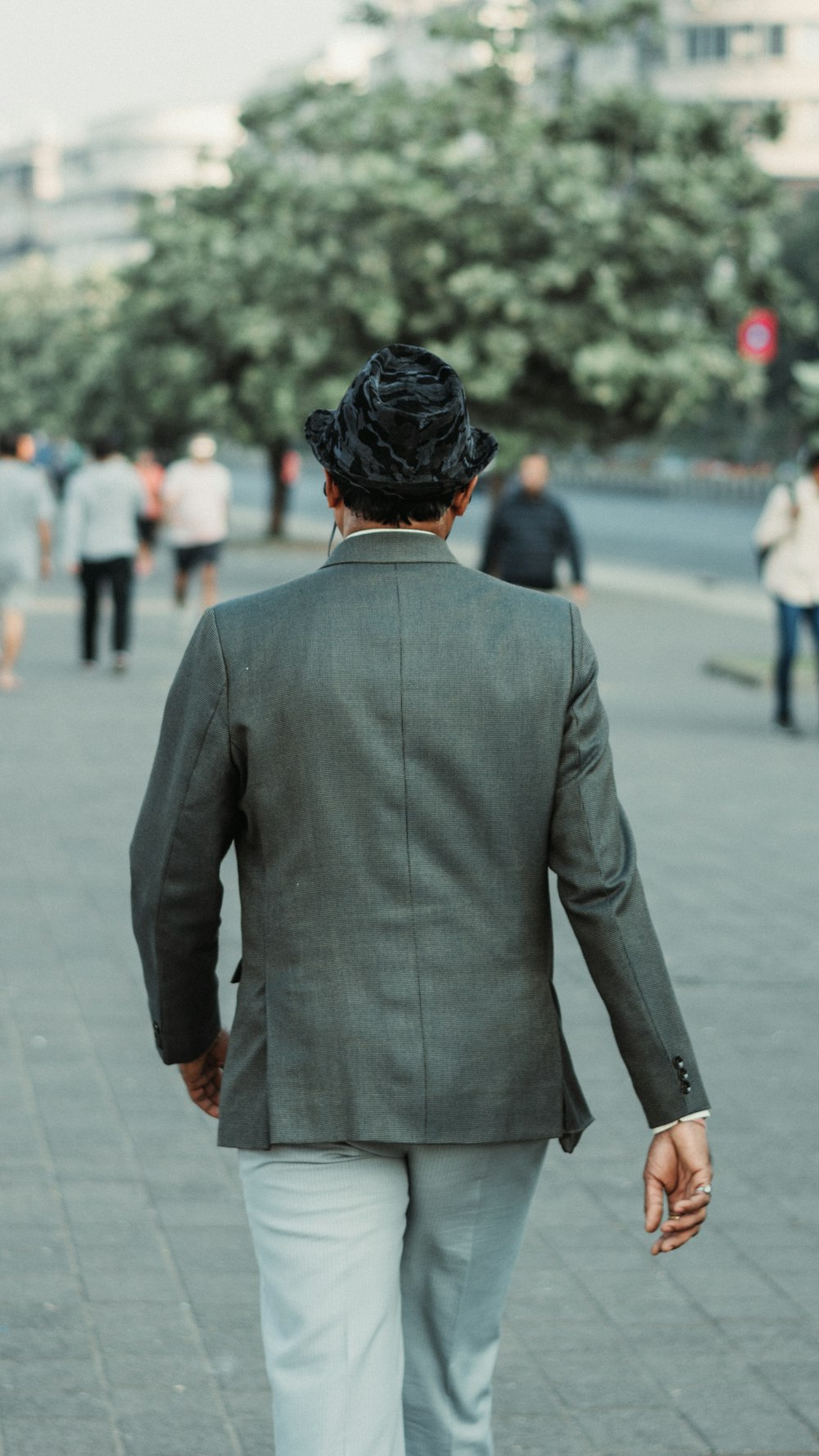 a man in a suit walking down a sidewalk