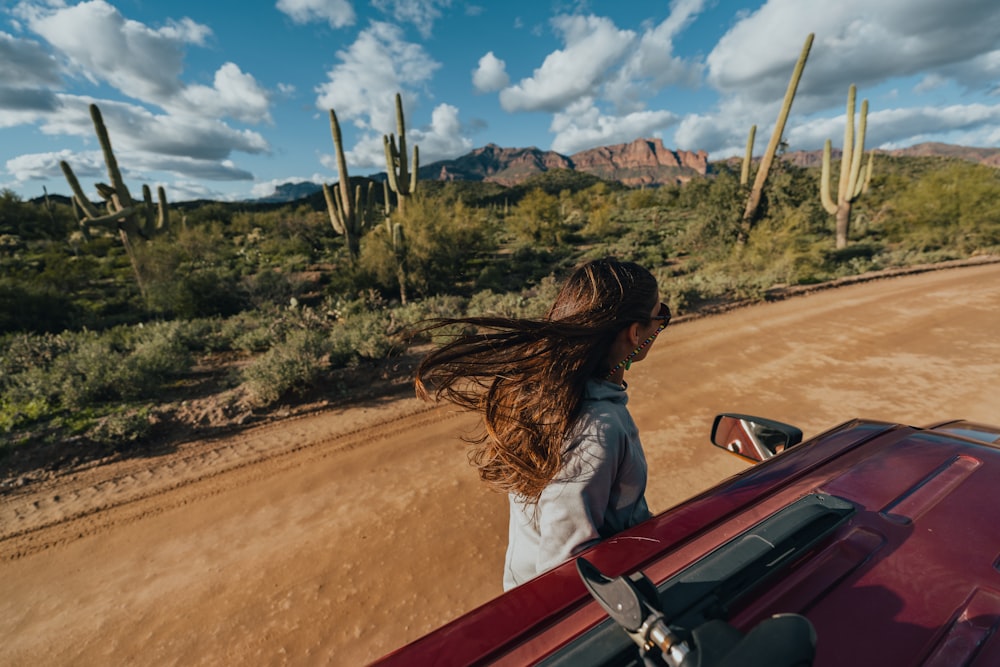 a woman riding in the back of a red truck