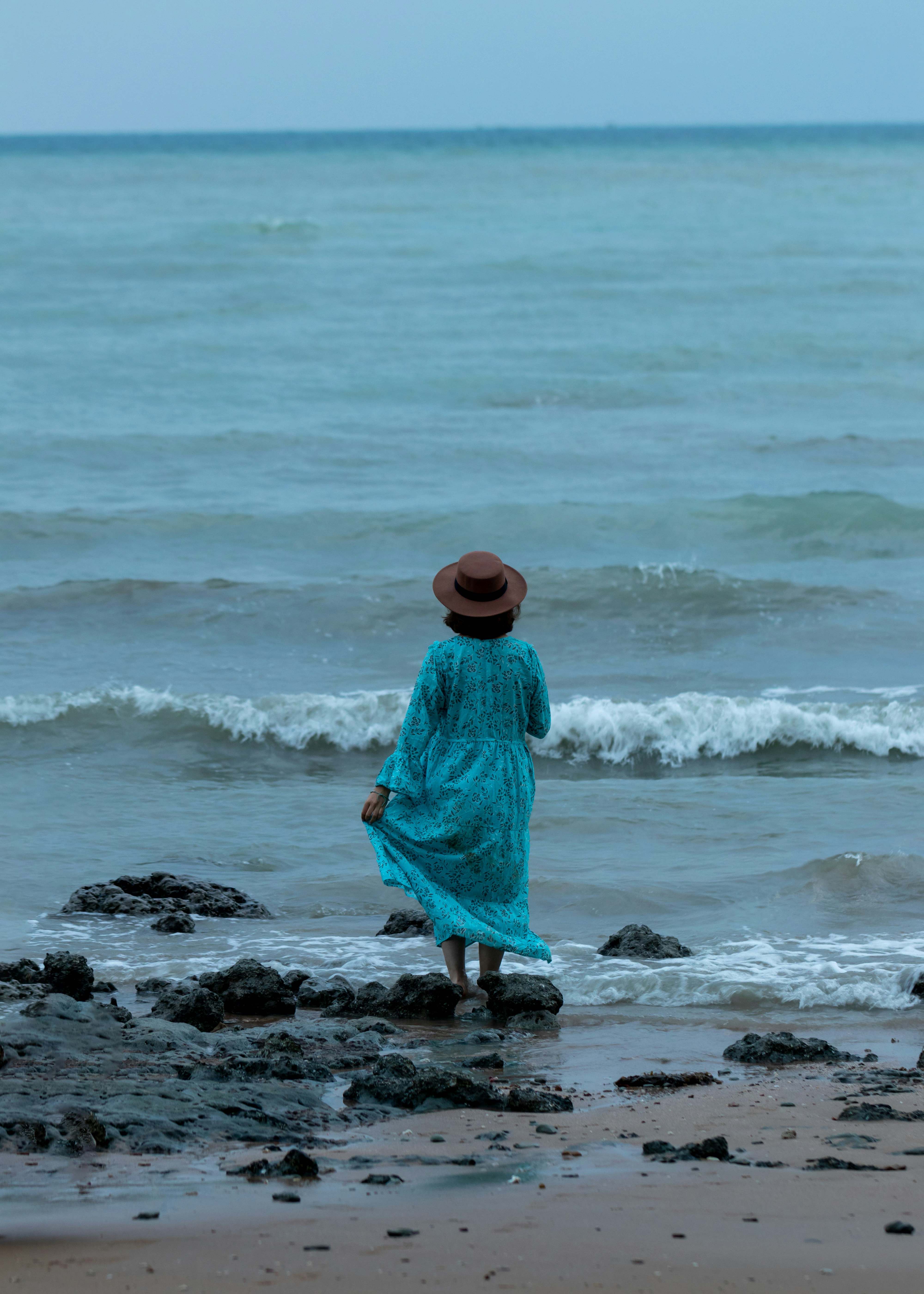 a person standing on a beach near the ocean
