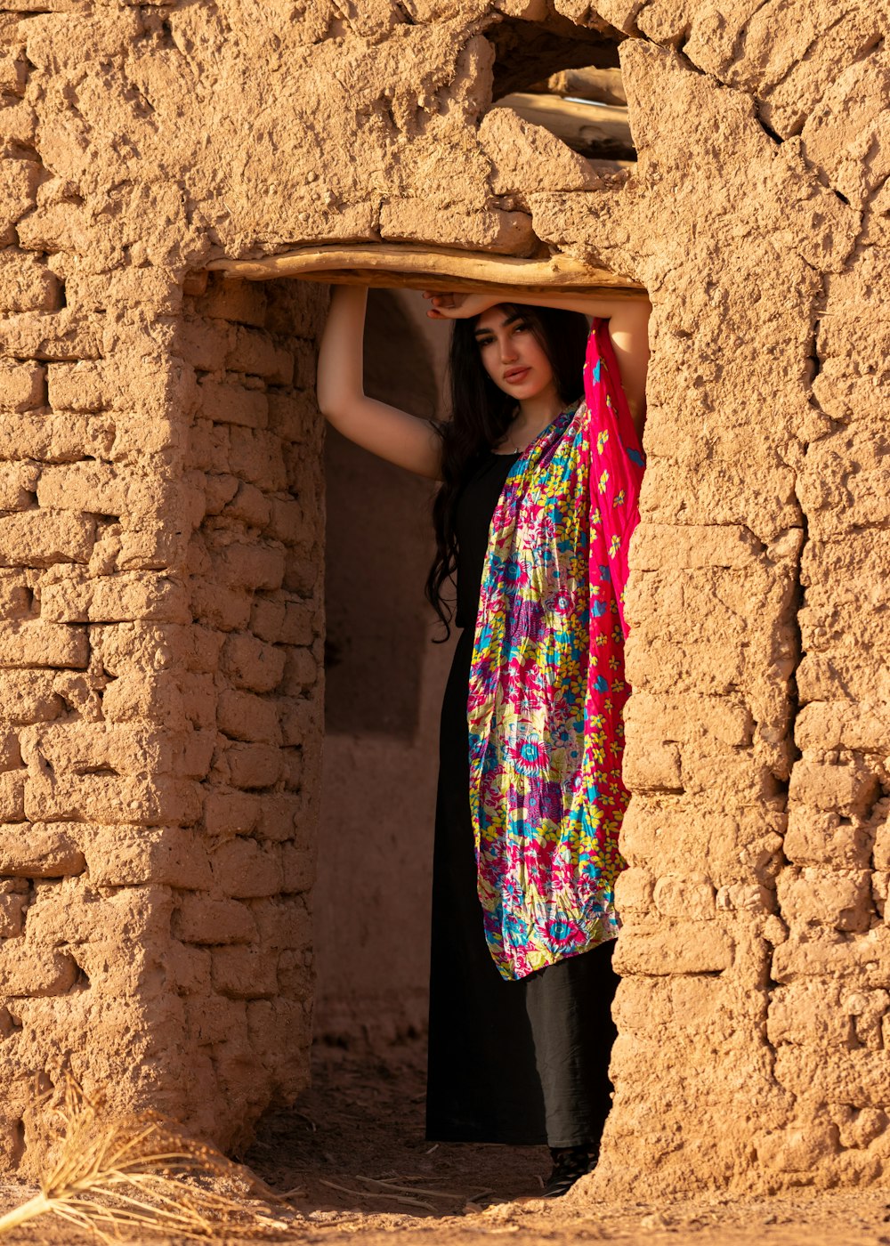 a woman standing in a doorway of a adobe building