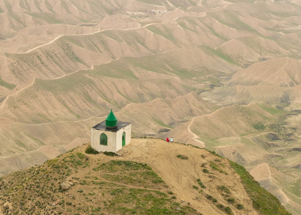 a small white building on top of a hill