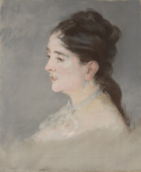A classical portrait of a woman in profile with dark hair styled in an updo. She wears a delicate lace shawl and an earring. The background is a muted gray tone, emphasizing the subject's soft expression and fine features.