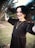 a woman in a black dress holding a cell phone