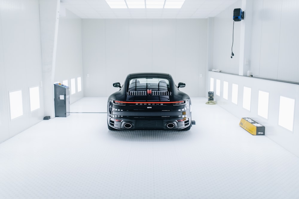a black car parked in a white garage