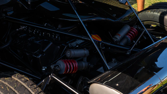 Close-up of a sleek air suspension strut with metallic and blue accents against a dark background