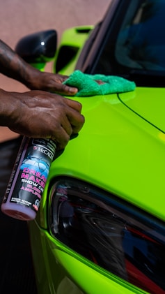 a person is cleaning a car with a sponge