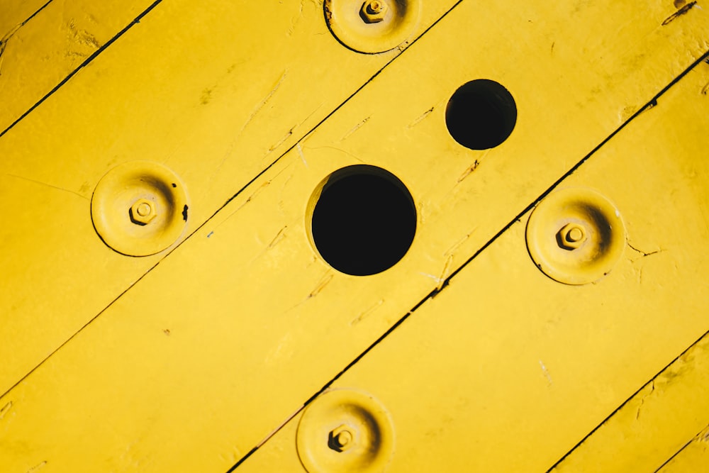 a close up of a yellow wall with holes in it