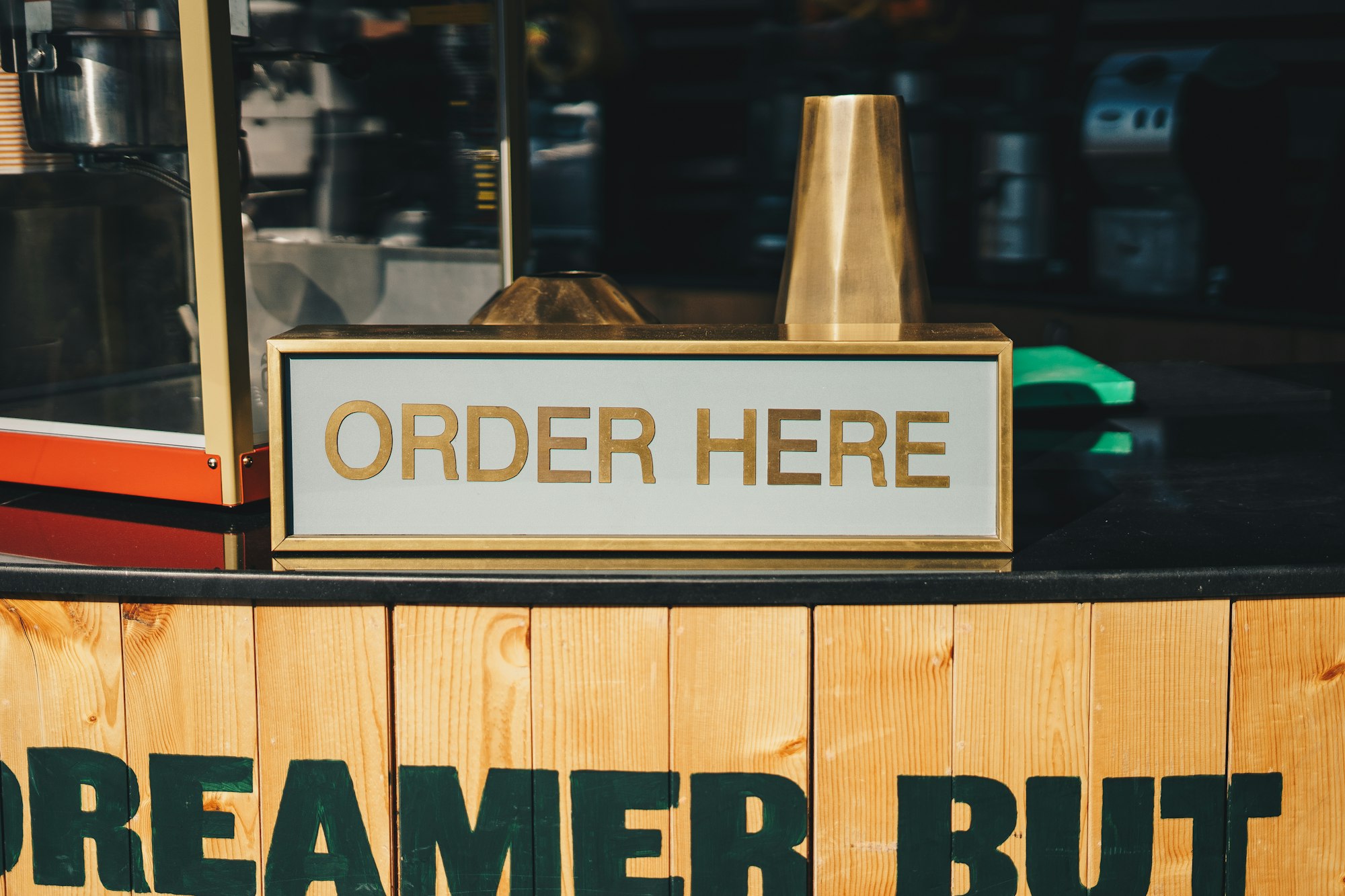 A sign in a restaurant that reads 'ORDER HERE'.