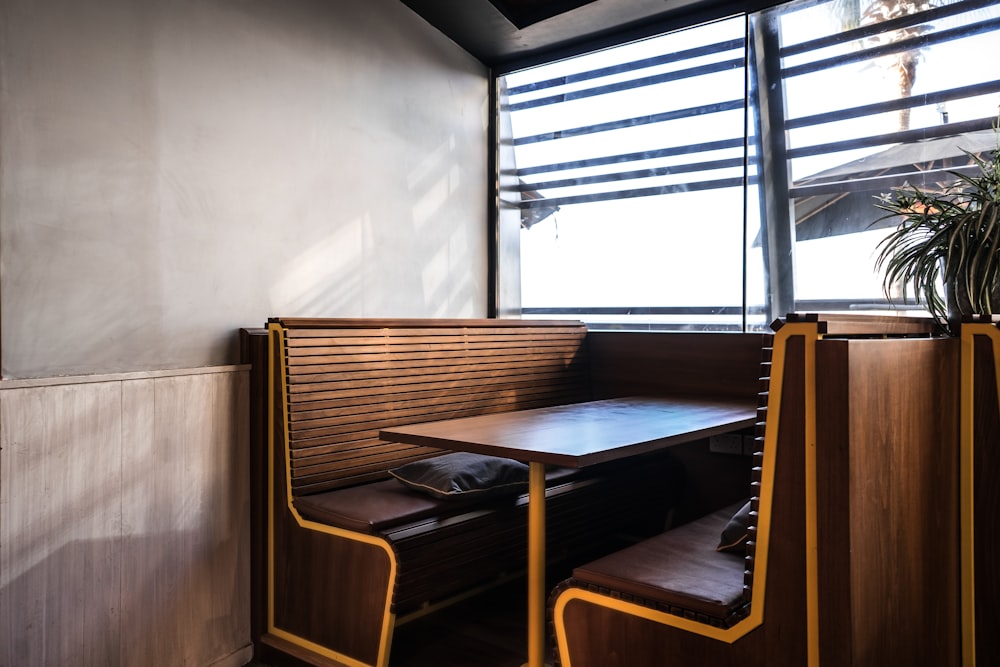 a table and benches in a room with a window