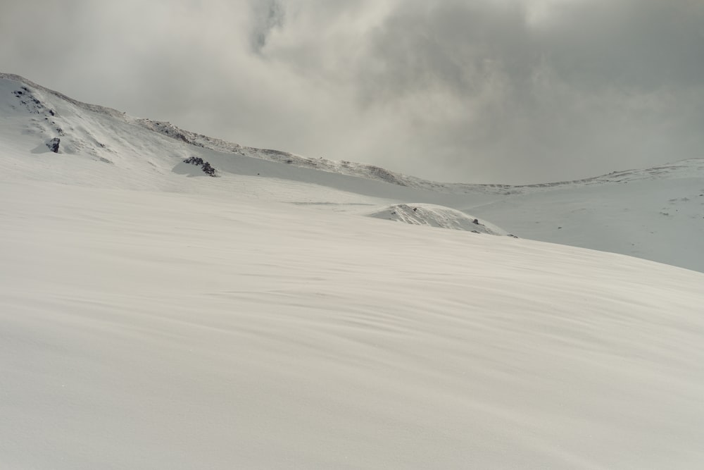 a person riding skis on top of a snow covered slope