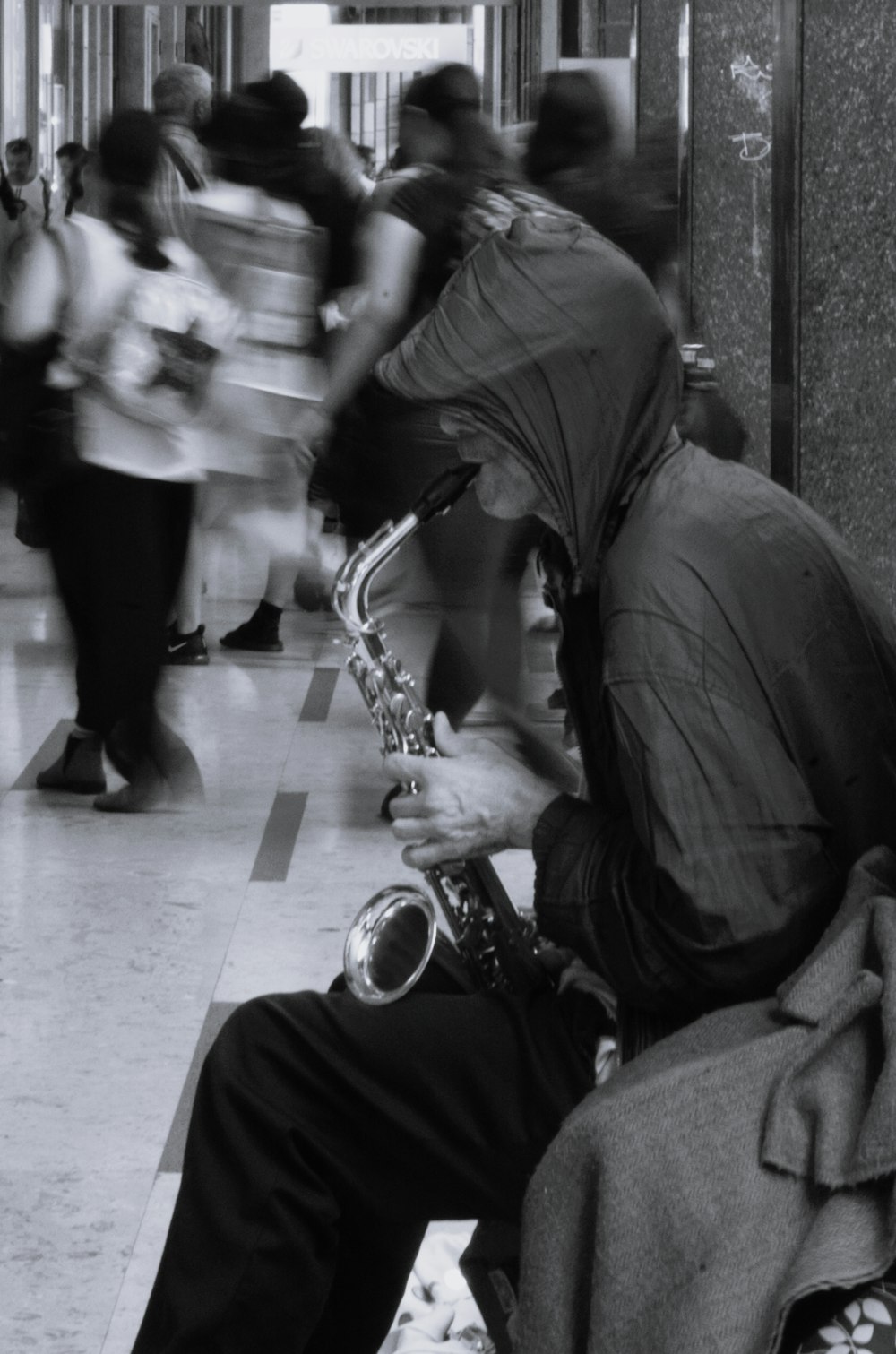 a man sitting on a bench playing a saxophone