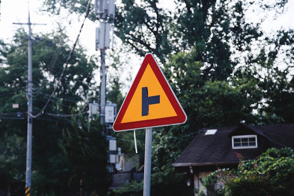 a street sign with a house in the background