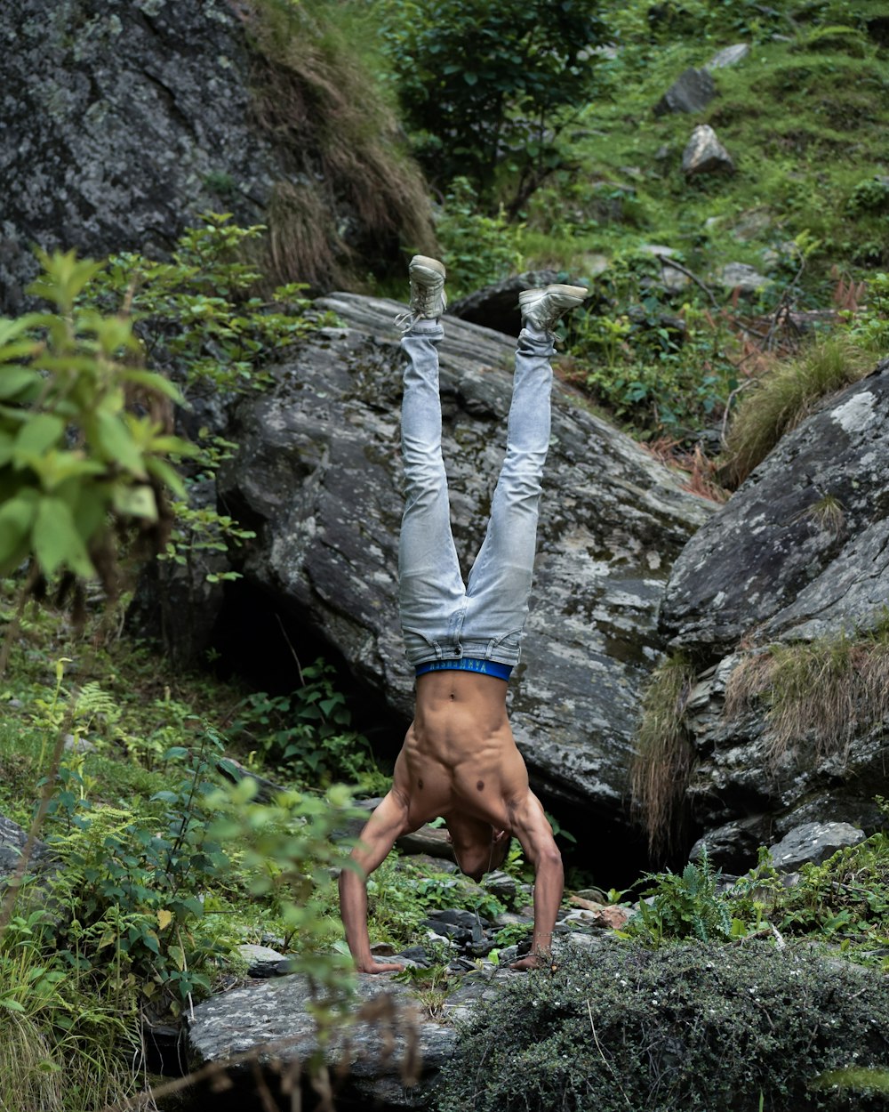 a man is doing a handstand on a rock