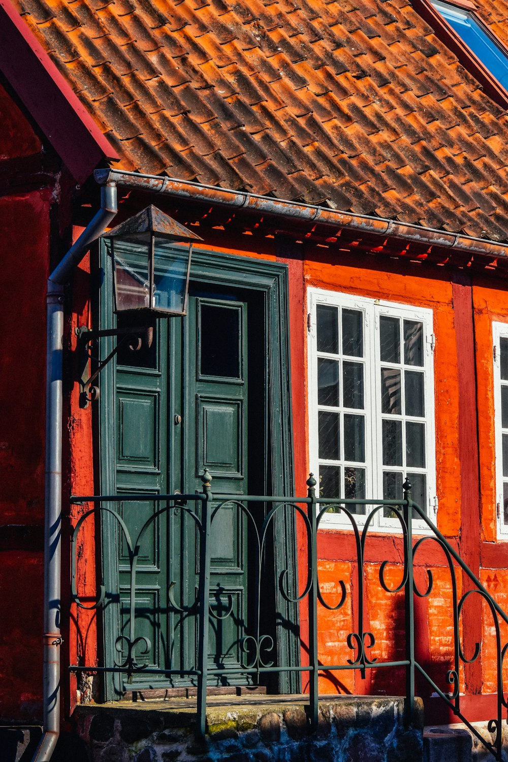 a red building with a green door and window