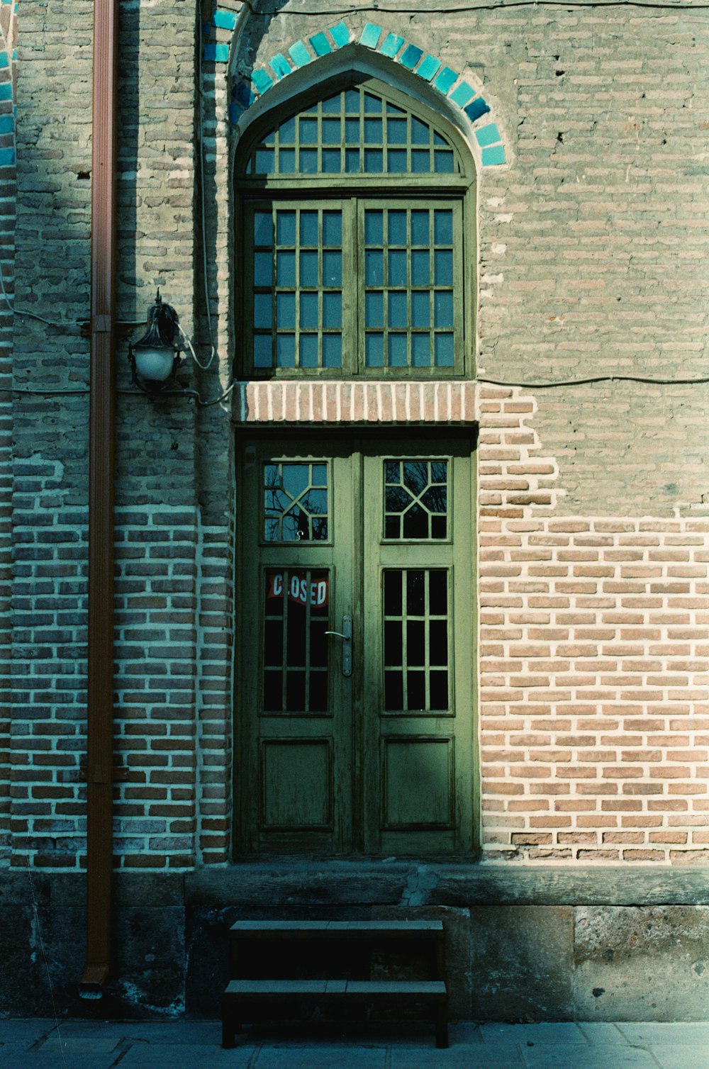 a building with a green door and a bench in front of it