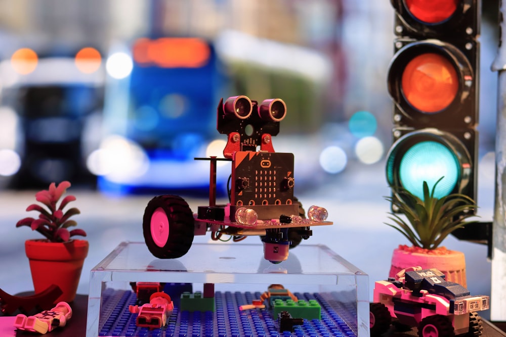 a toy robot is sitting on a table next to a traffic light