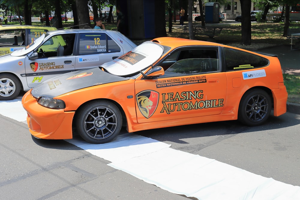 Ein orangefarbener Sportwagen parkt am Straßenrand