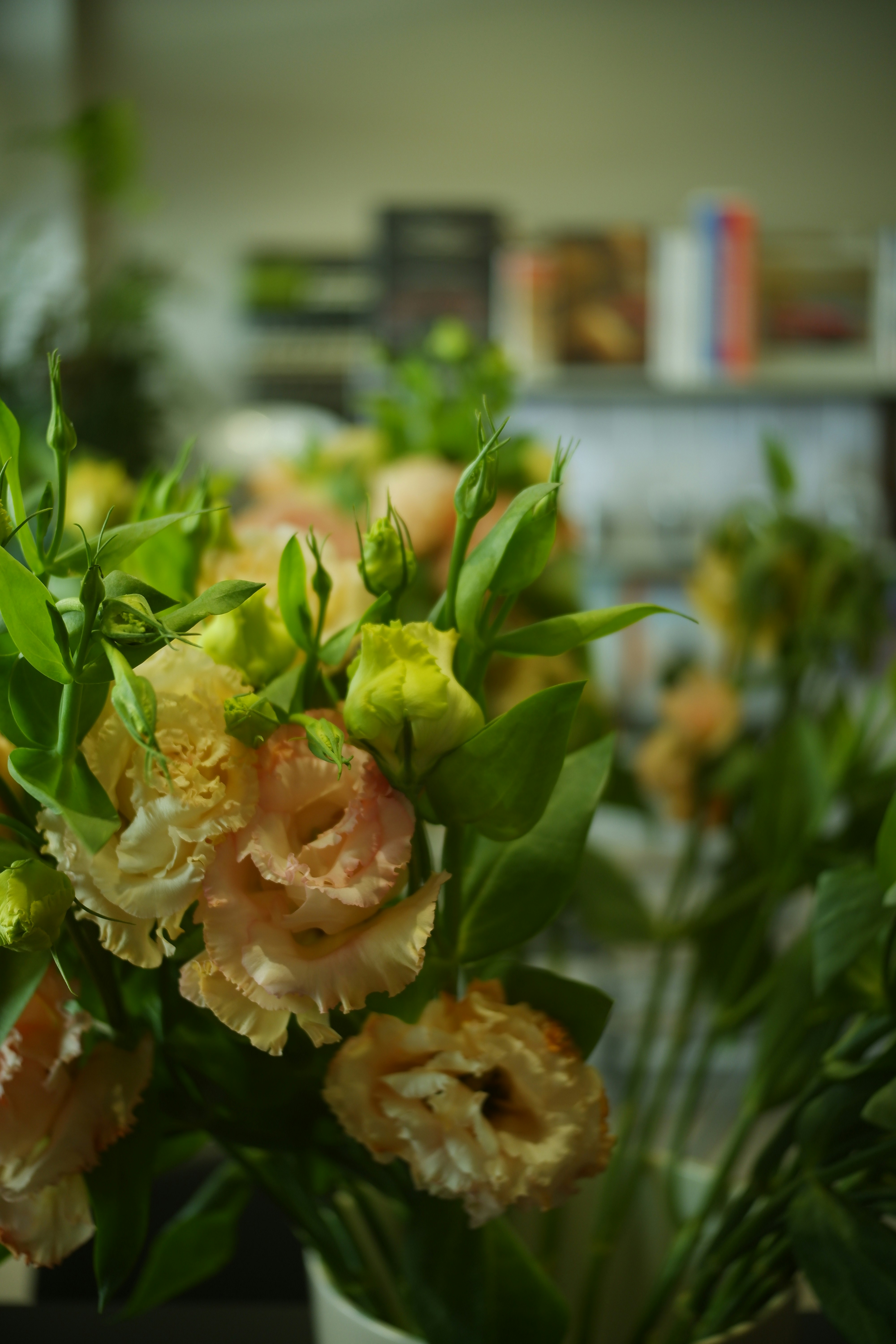 Warm sunset-toned lisianthus in peach and coral shades with greenery