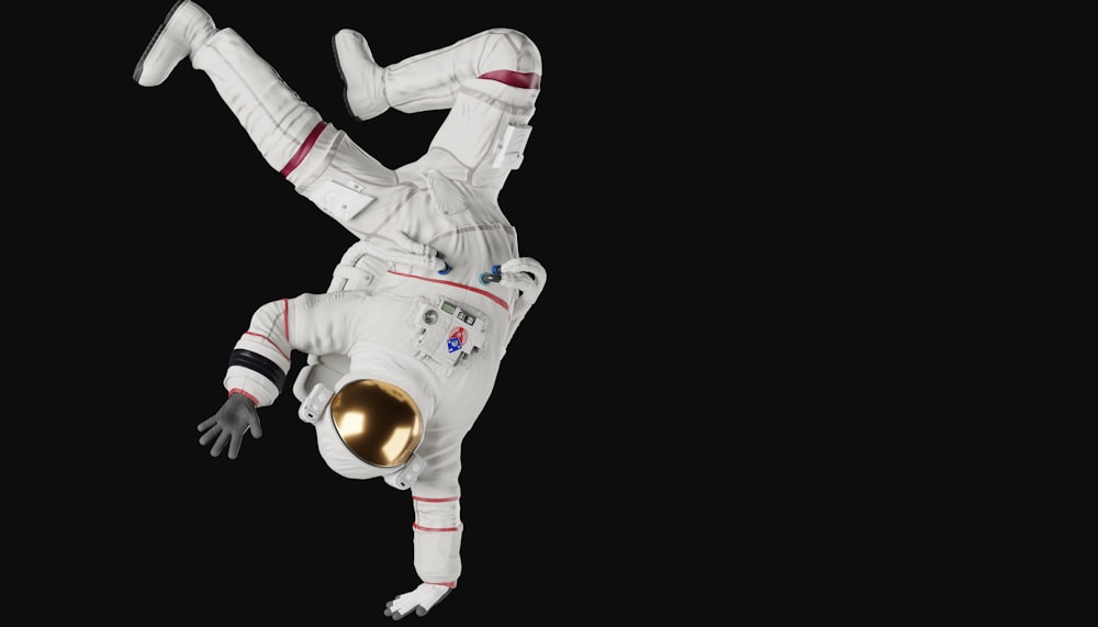 Una persona con un traje espacial blanco haciendo una parada de manos
