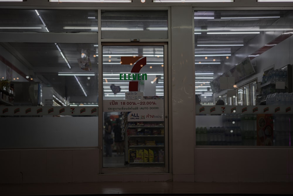 a store window with a sign that reads 7 eleven