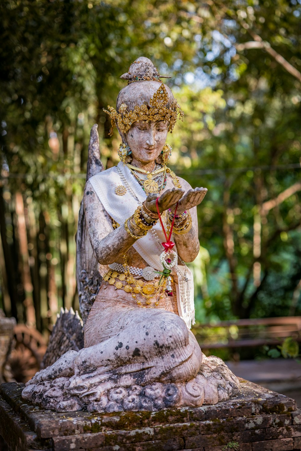 a statue of a woman sitting on a rock