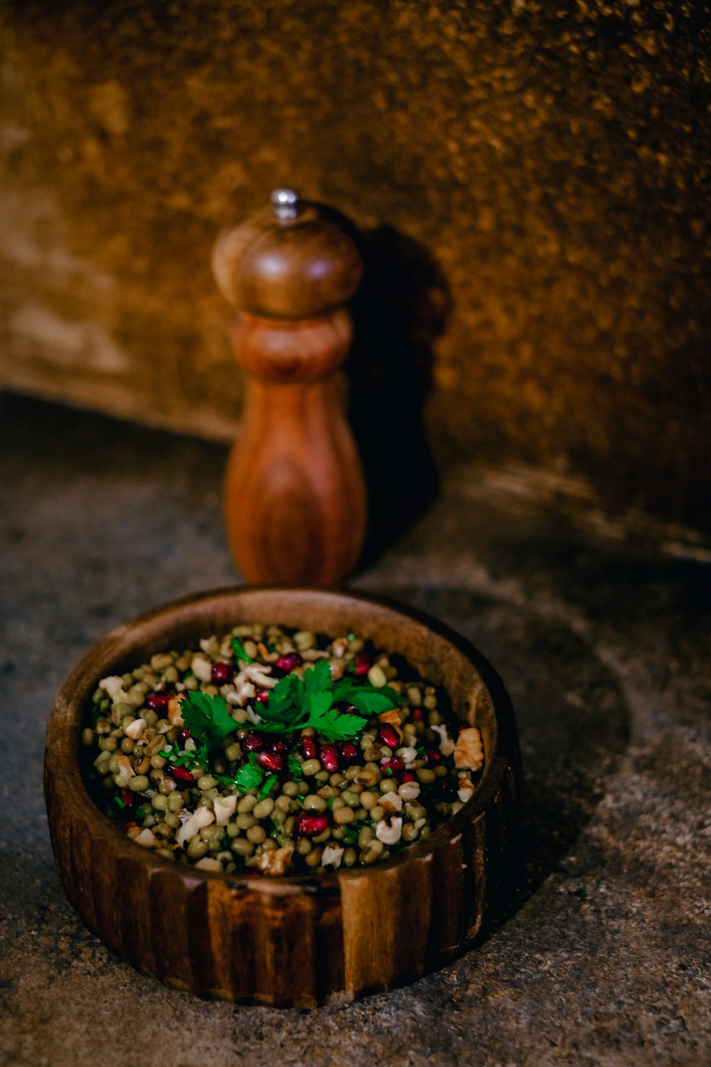 a wooden bowl filled with green and red food