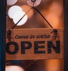 a wooden sign hanging from the side of a window