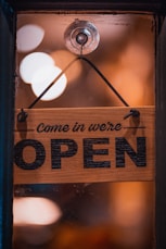 a wooden sign hanging from the side of a window