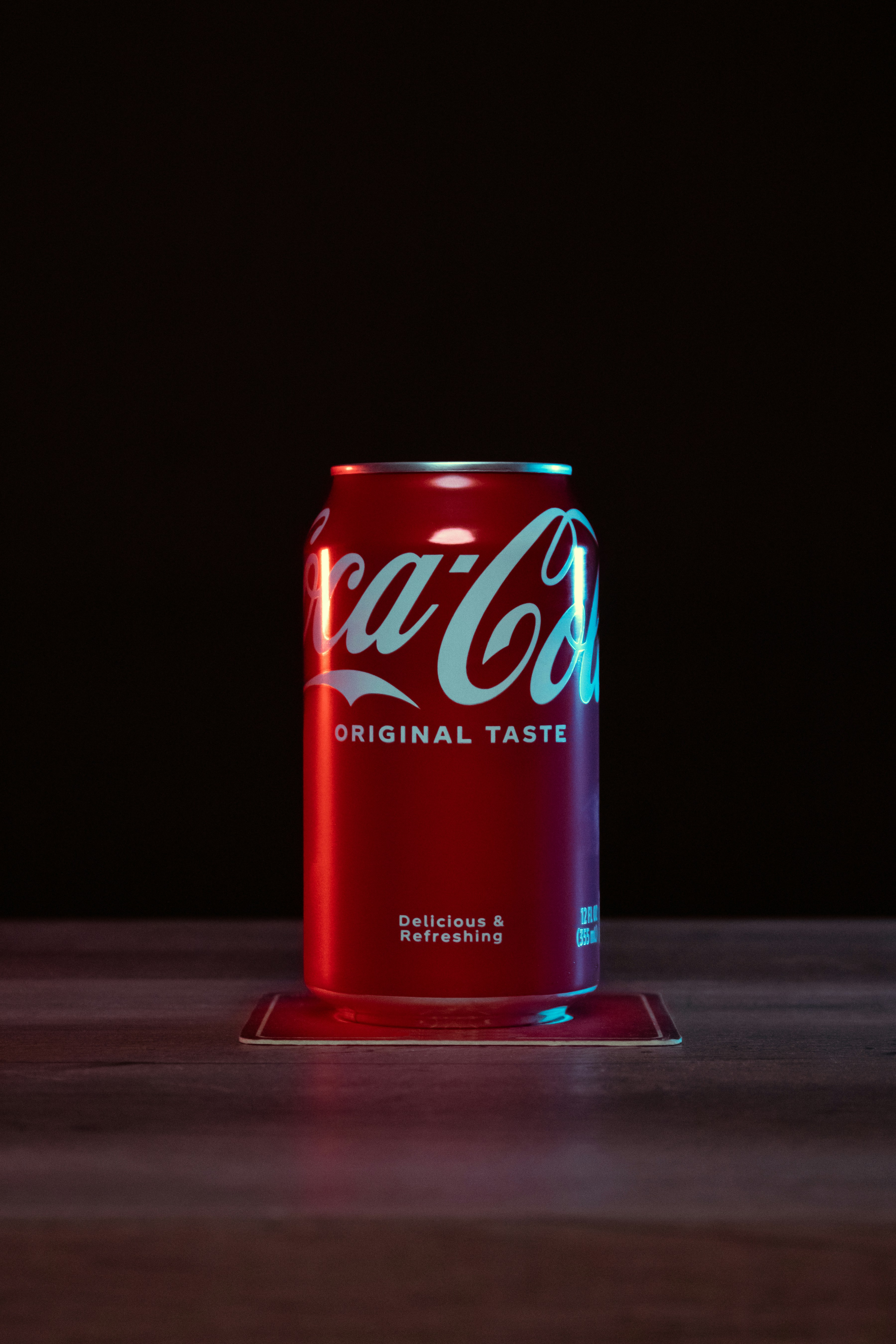 Coca-Cola can on table with red and blue lights