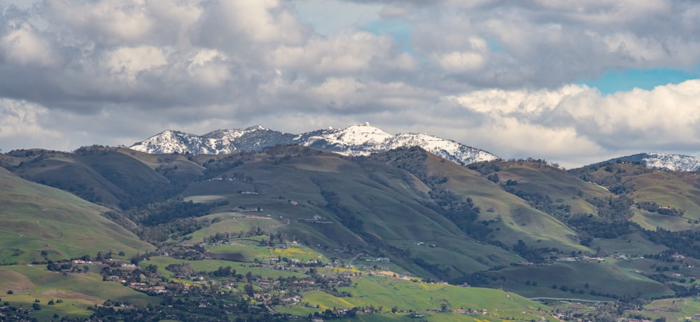 a view of a mountain range with snow capped mountains in the background