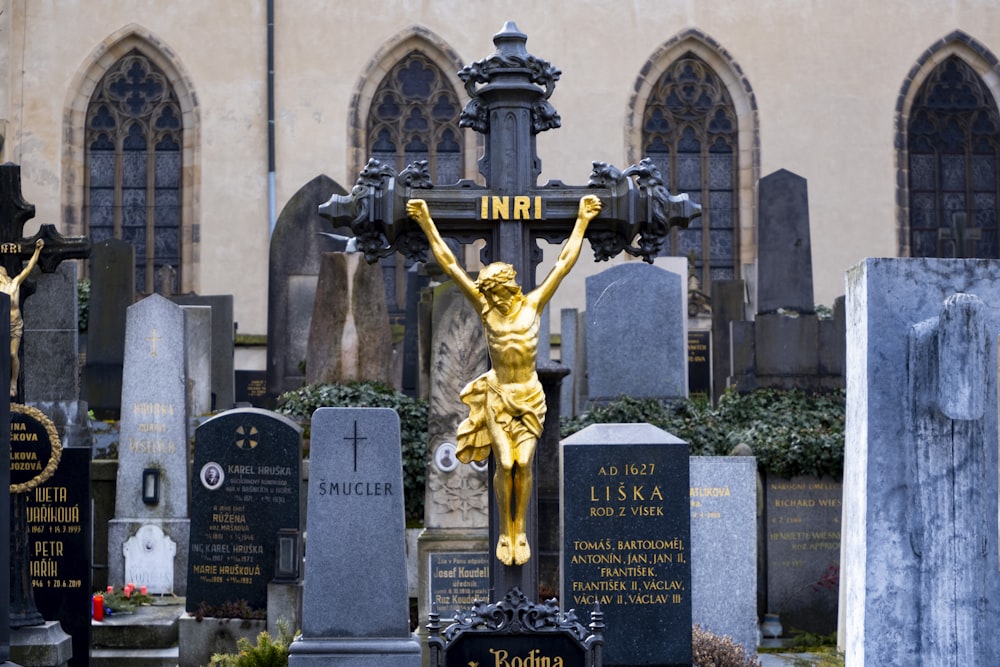 uma estátua de uma mulher segurando uma cruz em um cemitério