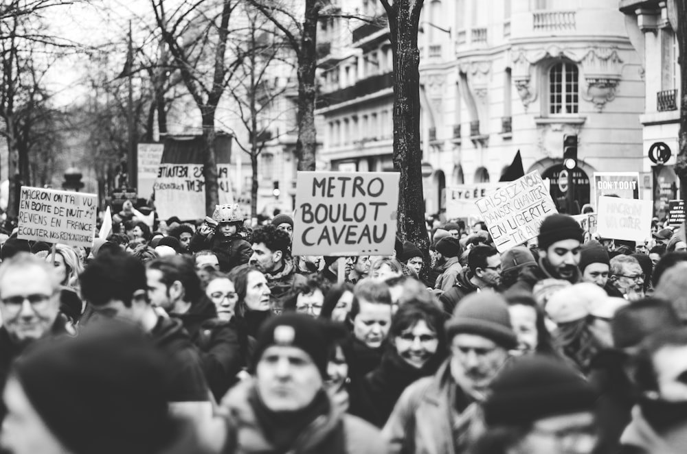 a large group of people holding signs in the street