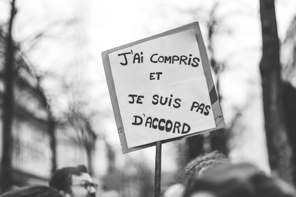 a person holding a sign that says i'm comptis et je sui