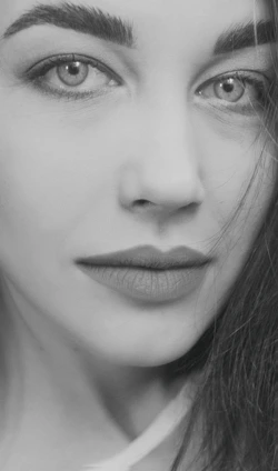 A sleek, minimalist black-and-white portrait of a model with soft lighting emphasizing fine details.