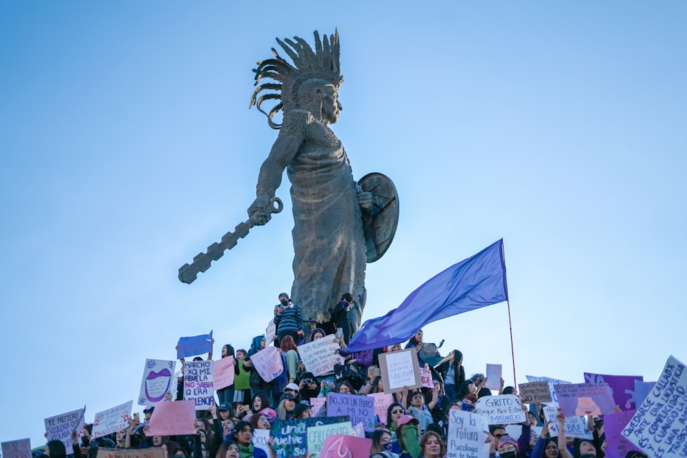 a crowd of people standing around a statue