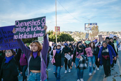 a group of people walking down a street holding signs
