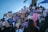 A large group of people gathering for a protest or demonstration, many holding signs with messages in Spanish advocating for women's rights and safety. The group appears to be standing on a staircase or slope with some people elevated higher than others. The sky is clear and blue, and the participants display various expressions of determination and solidarity.