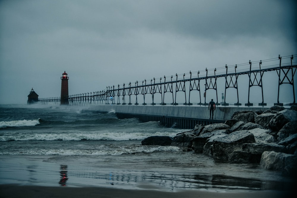 a light house sitting on top of a pier next to the ocean