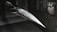 A model of a sleek, pointed aerospace vehicle with a sharp nose and aerodynamic fins is mounted inside a testing environment. The surroundings are metallic and industrial, with a perforated surface and visible instrumentation.