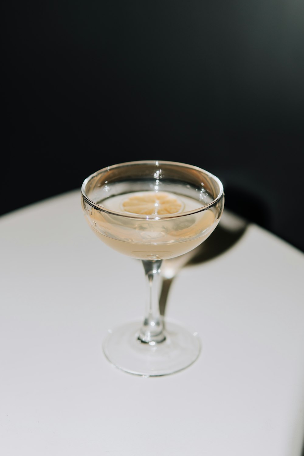 a glass filled with liquid sitting on top of a table